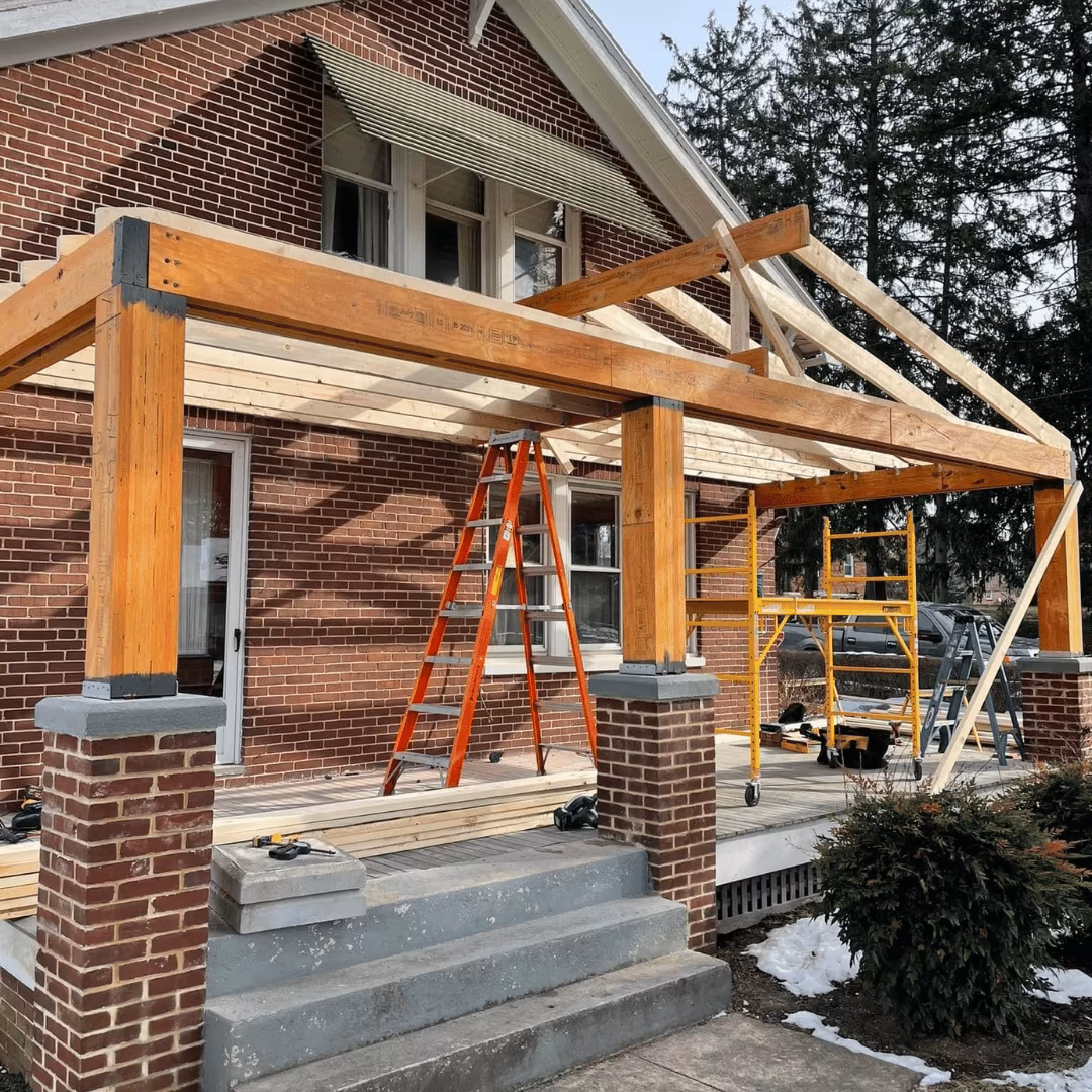 Timber porch frame under construction on a brick house