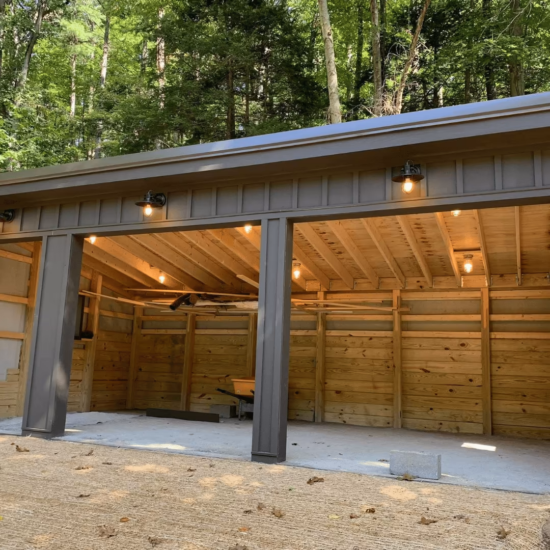 Open garage bay with wood walls and exposed ceiling joists