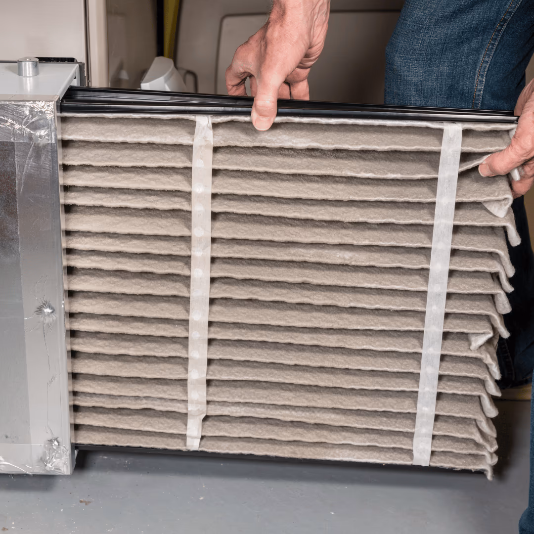 Hands holding a pleated HVAC air filter