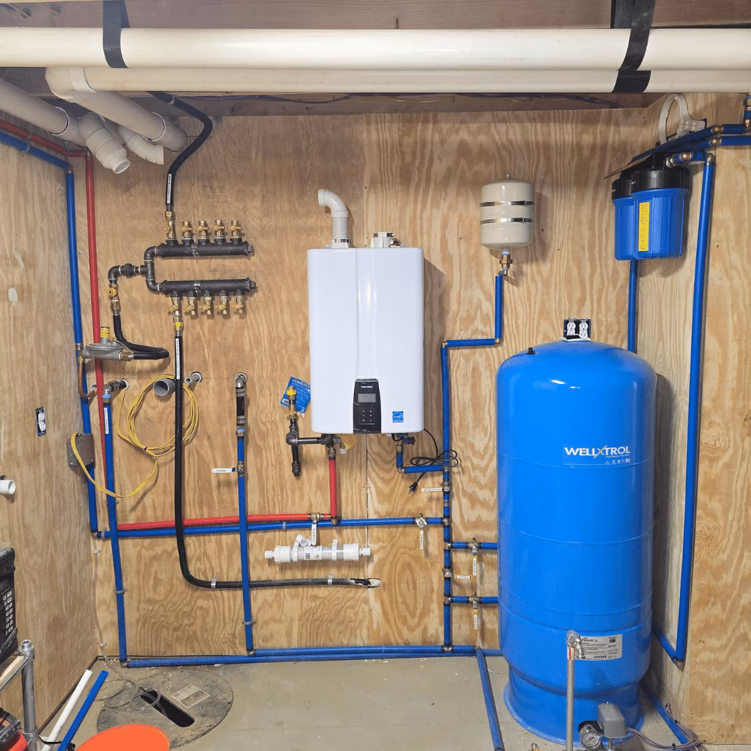 Tankless water heater and blue pressure tank in a utility room