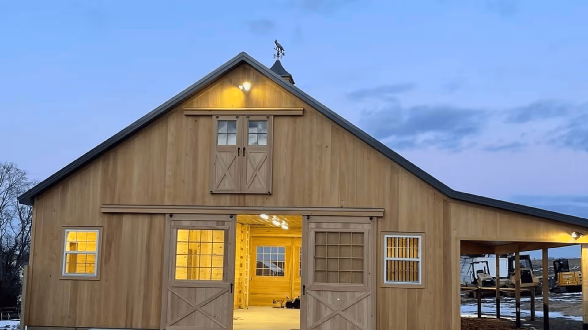 Barn with warm light glowing from the windows at dusk