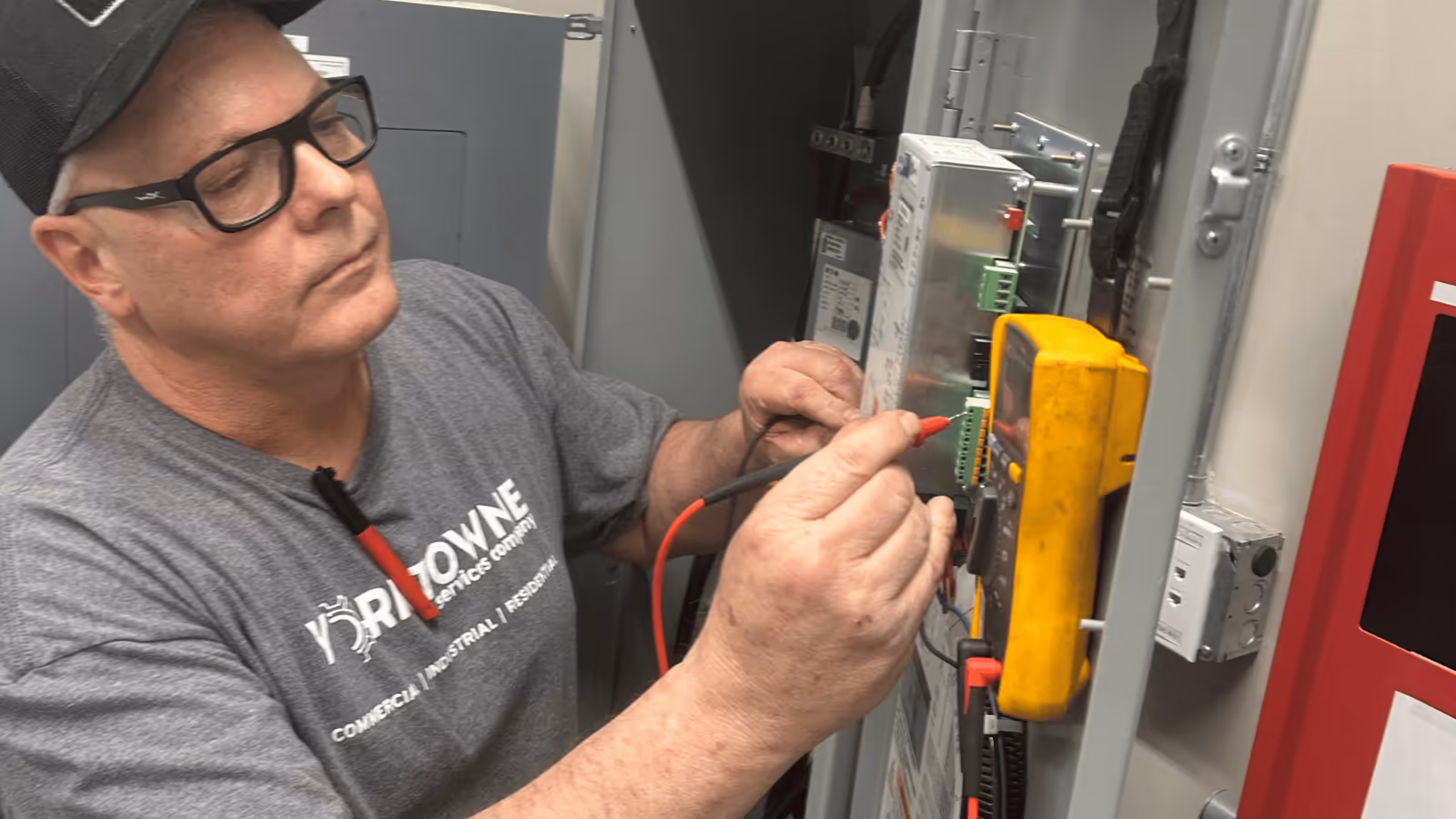 Yorktowne electrician testing a panel with a multimeter